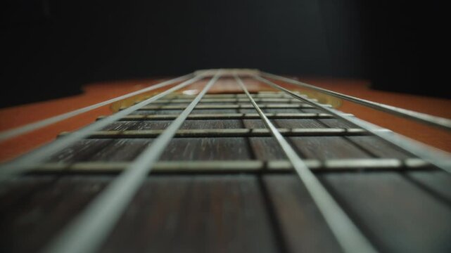 Close-Up Probe Lens Shot Along Guitar Neck and Strings