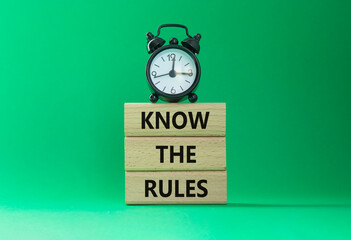Know the rules symbol. Wooden blocks with words Know the rules. Beautiful green background with...