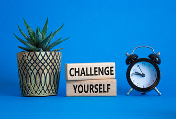 Challenge yourself symbol. Wooden blocks with words Challenge yourself. Beautiful blue background...
