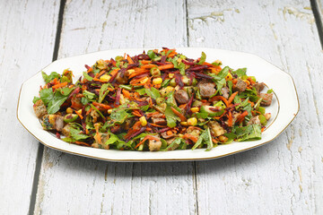 Mixed fresh Turkish salad. Carrots, arugula, cucumber, basil, pepper, black cumin, pepper, corn and plenty of olive oil in a serving plate. Healthy summer food.