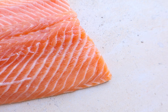 Primer plano de un filete de trucha noruega fresca que destaca la textura detallada de la carne y sus vetas. Imagen minimalista y limpia, ideal para contenido gastron&oacute;mico, saludable o de dise&ntilde;o edito