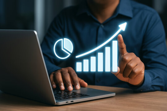 Businessman analyzing financial growth with virtual bar and pie chart using laptop in office