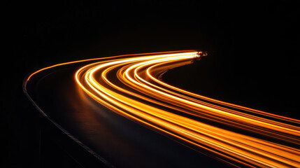 Long exposure captures illuminated curves of winding road at night showing movement and light trails