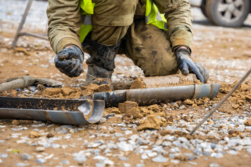 Man cutting and cleaning soil sample for laboratory analysis. Preparation of core material for geotechnical testing and scientific evaluatio