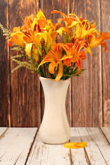 Still life with beautiful lily and daylily flowers in vase on elegant modern background, summer...