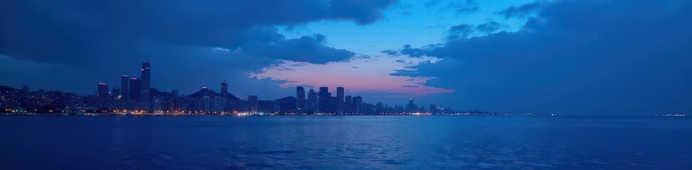 Fototapeta premium Dark blue sky with silhouetted cityscape and sea , skyline, night