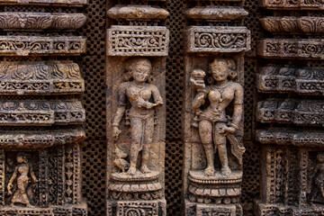 A close-up view of detailed stone carvings on the wall of Konark sun temple, an ancient temple.
