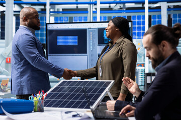 Solar panels plant businesspeople doing welcoming handshake, brainstorming how to increase...