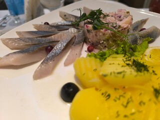 delicious pieces of herring next to fried potatoes