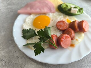 morning breakfast on white plate with fried eggs and fried sausages