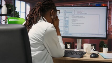 Woman feeling worried while looking at UI on PC screen, having trouble executing programming code....