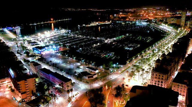 Nocturne aerial view of Alicante port, Postiguet Beach and the buildings next to the city center in the Mediterranean city of Alicante, Spain.