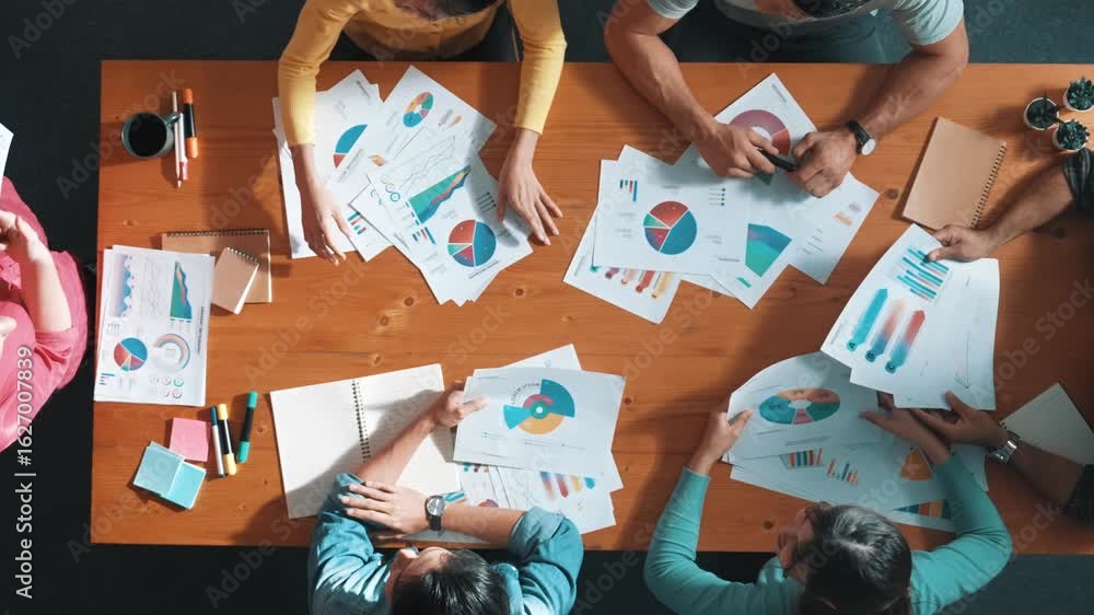 Poster top down view of start up business team holding paper while discussing about financial idea. aerial 