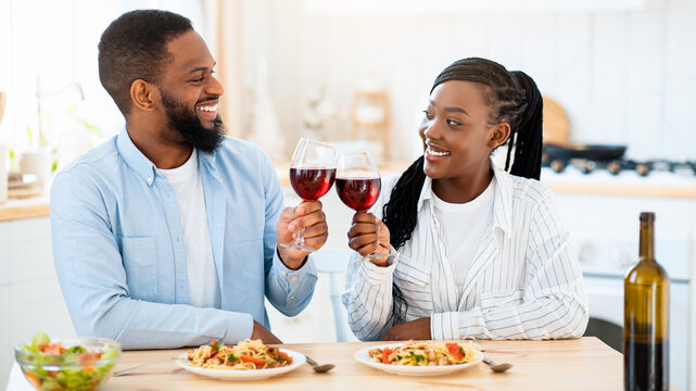 Quarantine Dates. Happy Black Couple Drinking Red Wine And Having Lunch At Home, Loving African American Spouses Sitting At Table In Kitchen, Enjoying Spending Time Together, Closeup Shot - Powered by Adobe