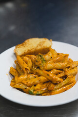 Delicious Penne Pasta with Creamy Orange Sauce Served in a White plate