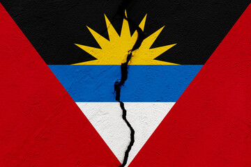 The flag of the Antigua and Barbuda into a grunge cracked wall