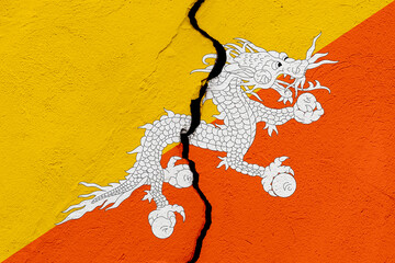 The flag of the Kingdom of Bhutan into a grunge cracked wall