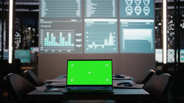 Boardroom is staged for success with green screen and forecasting visuals in empty office at night, ideal setting for corporate alignment and late project briefings. Management tools.