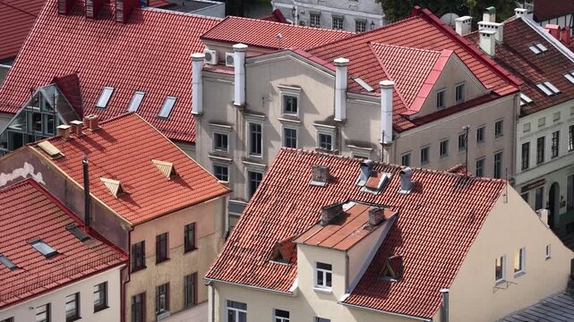 Close-up view of traditional red clay tiled rooftops in Klaipėda Old Town, Lithuania, featuring historic architecture with chimneys, dormer windows, and classic facades.