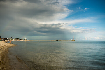 Summer sea horizon with clouds, beach baskets, seagulls

