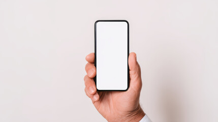 A hand holding a sleek smartphone with a blank screen against a neutral background.