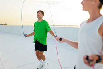 Fitness enthusiasts engage in a spirited jump rope session on a waterfront promenade during the...