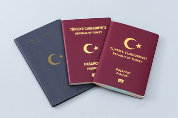 Old and New Turkish citizen public passports on the blue background.