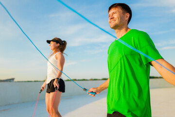 Jumping into fitness on a sunny rooftop with friends, enjoying a refreshing workout session...