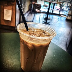Grainy Iced Latte in Busy Coffee Shop – Authentic Ambient Shot with Muted Tones for Real-Life Branding