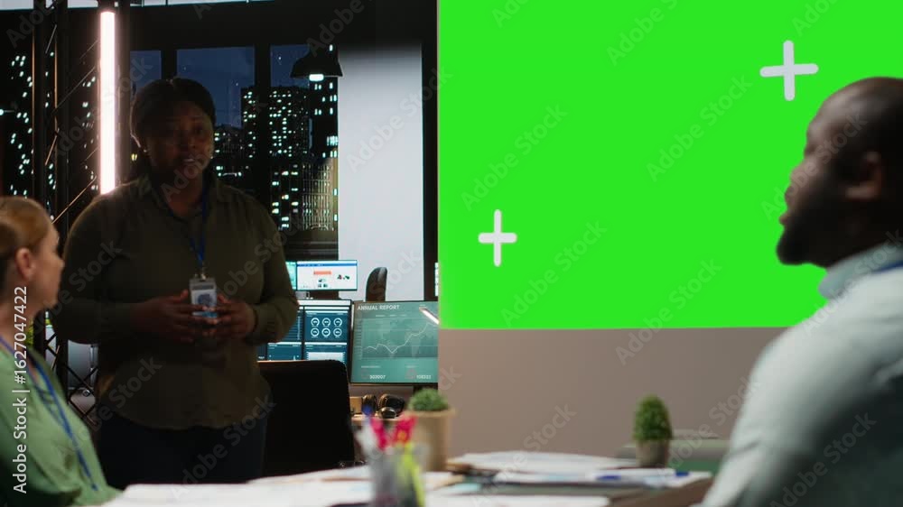 Poster diverse team in a dark office shares insights and exchanges feedback, finalizing company agenda duri