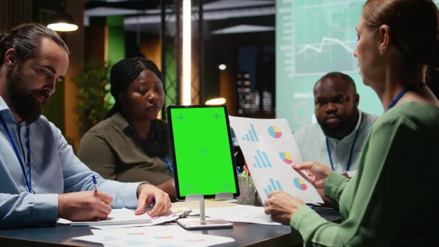 Diverse team in a dark office shares insights and exchanges feedback, finalizing company agenda during a collaborative project briefing with global stakeholders. After hours discussion. Camera A.