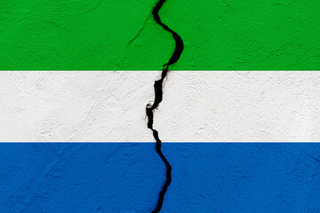 The flag of the Republic of Sierra Leone into a grunge cracked wall