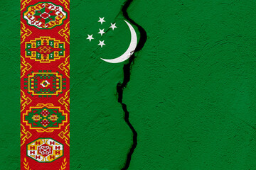 The flag of Turkmenistan into a grunge cracked wall