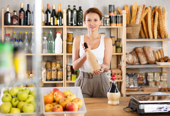 Female salesperson offers to buy bottle of wine in liquor department of a grocery supermarket
