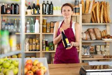 Adult saleswoman offers to buy bottle of wine in grocery store