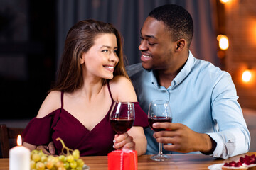 Affectionate Multicultural Couple Enjoying Date In Restaurant, Celebrating Valentine's Day Together, Interracial Lovers Having Romantic Dinner, Drinking Wine And Smiling To Each Other, Free Space