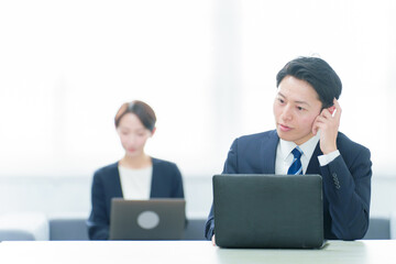 フリーアドレスでデスクワークをするビジネスパーソン