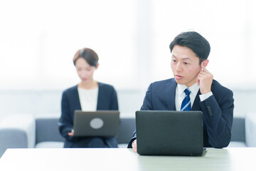 Fototapeta premium フリーアドレスでデスクワークをするビジネスパーソン