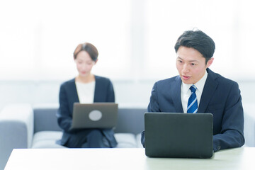 Fototapeta premium フリーアドレスでデスクワークをするビジネスパーソン