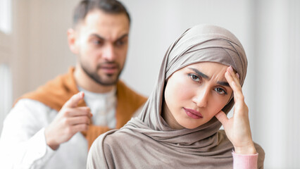 Angry Muslim Husband Shouting At Unhappy Wife While She Looking At Camera Standing At Home....