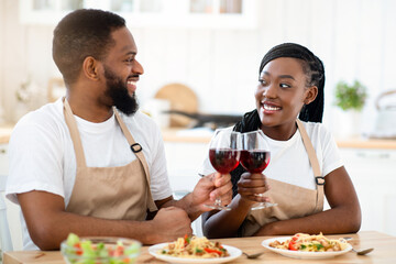 Young Romantic African American Couple Drinking Wine And Eating Spaghetti In Kitchen, Cheerful Black Lovers Clinking Glasses, Having Date At Home, Enjoying Spending Time Together, Closeup Shot