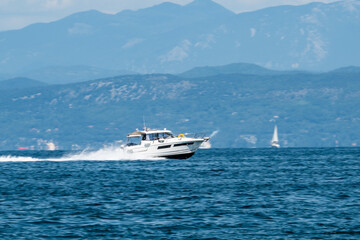 Fototapeta premium Speedboat Racing on the Adriatic Sea with Mountain Backdrop Near Koper Slovenia