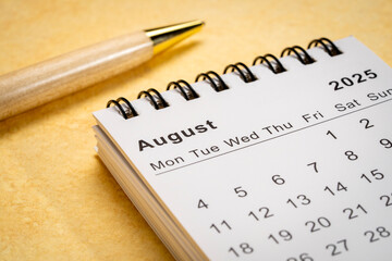 August 2025 - small spiral desktop calendar, time and business concept