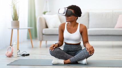 VR Yoga. Black Lady Sitting In Lotus Position Wearing Virtual Reality Headset Doing Yoga And...