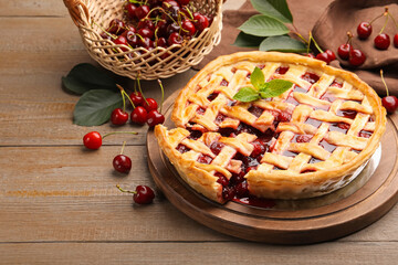 Tasty cut cherry pie and berries on wooden table, closeup