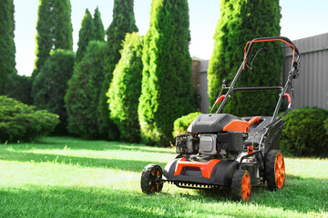 Obraz premium One lawn mower on green grass in garden, space for text