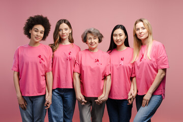Interracial women wearing pink ribbons supporting breast cancer awareness