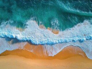 Aerial view of turquoise ocean waves crashing onto a golden sandy beach with white foam creating textured patterns along the shore
