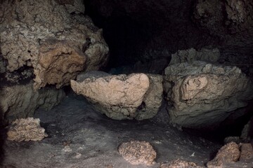 Dark cave interior with rock formations and a sense of mystery.