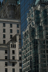 A close-up shot of older architectural styles reflecting in modern glass skyscrapers, showcasing...